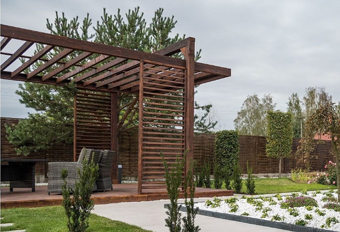 Pergola w ogrodzie – dwa pomysły na typowe zaaranżowanie zieleni z drewnianą pergolą w tle